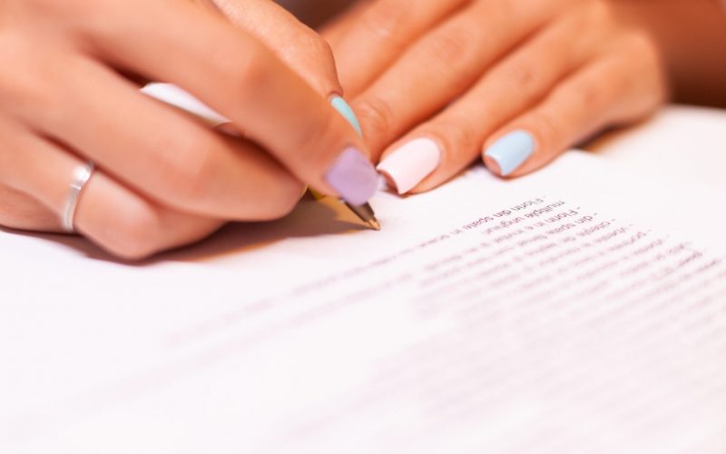 Close up of woman writing on clipboard during podcast. Influencer taking notes on clipboard while talking with followers during live on social media, creative online show On-air production broadcast