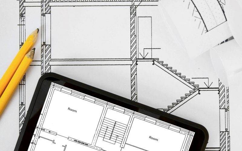 Planning of construction of the house. Tablet, drawings and working tools.